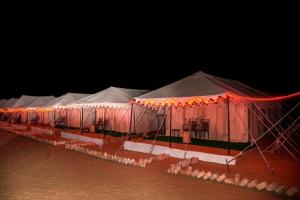 a row of tents in the water at night at Mehta Desert camp Sam sand Dunes Jaisalmer in Jāmb +4 photos