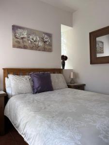 a bedroom with a white bed with purple pillows at Sequoia cottage in Bersac-sur-Rivalier +12 photos