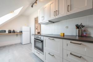 a kitchen with white cabinets and a white refrigerator at Bel appartement au centre Colmar stationnement in Colmar