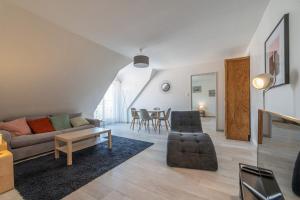 a living room with a couch and a table at Bel appartement au centre Colmar stationnement in Colmar