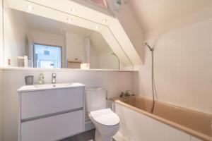 a bathroom with a toilet and a sink and a tub at Bel appartement au centre Colmar stationnement in Colmar