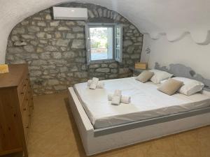 a bedroom with a large bed in a stone wall at Rose Home in Areopoli