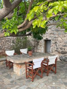 a stone table and chairs under a tree at Rose Home in Areopoli