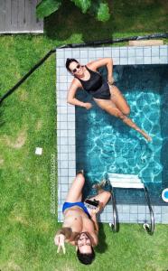 two women are swimming in a swimming pool at Casa com piscina privativa Praia da Pipa #2 in Tibau do Sul