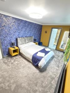 a bedroom with a bed and a blue wall at Seaside Retreat in Harrington