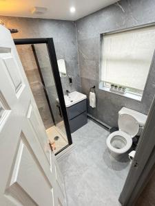 a bathroom with a toilet and a sink and a window at Seaside Retreat in Harrington +17 photos