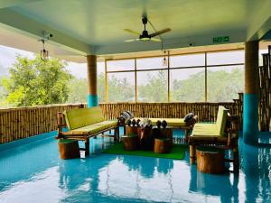 a screened in porch with chairs and tables in the water at Bhūma in Havelock Island