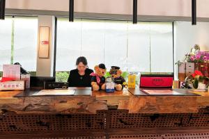 a woman sitting at a counter with two teddy bears at W9-Hotel ShangHai PuDong Ariport in Shanghai