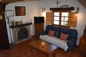 a living room with a couch and a fireplace at Finca La Sierra with private Pool in Cómpeta