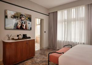 ein Hotelzimmer mit einer Person, die mit einer Kamera ein Foto macht in der Unterkunft The Grand Hotel Leicester by The Unlimited Collection in Leicester