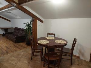 a dining room with a table and chairs and a couch at ANNA Home in Craiova