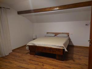 a bedroom with a bed and a wooden floor at ANNA Home in Craiova