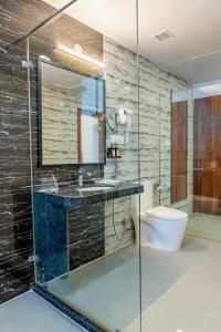 a bathroom with a glass shower and a toilet at Hotel Paandora Grand,Udaipur in Udaipur