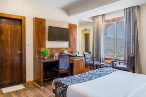 a hotel room with a bed and a desk at Hotel Paandora Grand,Udaipur in Udaipur