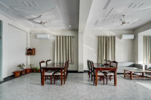 a dining room with a table and chairs and a couch at Collection O Kesar Crossway Jaipur Formerly Laxmi Palace in Jaipur