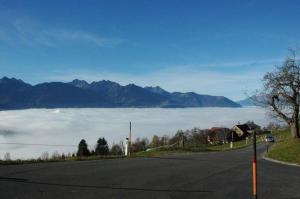 a road with a view of a fog covered mountain at Ferienhaus Dünser In Dünserberg in Bürserberg +18 photos