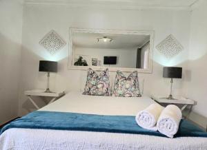 een slaapkamer met een bed met kussens en een spiegel bij Zhantique Guest House 1- Unit 5 in Boksburg