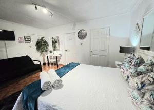 een slaapkamer met een wit bed en een bank bij Zhantique Guest House 1- Unit 5 in Boksburg