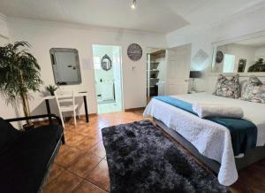 een slaapkamer met een bed, een tafel en een stoel bij Zhantique Guest House 1- Unit 5 in Boksburg +25 foto's