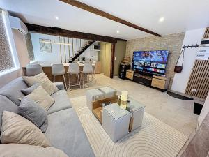 圣贝尔特朗德科曼日L'élégance au Comminges - balnéo, cinéma & confort的客厅里有一张沙发和一台电视