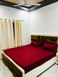 a bedroom with a large bed with red sheets at Shri omkarnath Guest house Ayodhya in Ayodhya