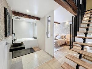 圣贝尔特朗德科曼日L'élégance au Comminges - balnéo, cinéma & confort的房间里有带水槽的浴室和一张床