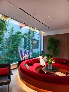 a living room with a red couch and a large window at W9-Hotel ShangHai PuDong Ariport in Shanghai