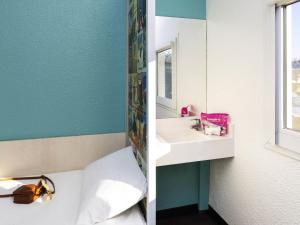 a bathroom with a sink and a tub and a mirror at HôtelF1 Angoulême in Champniers +58 photos