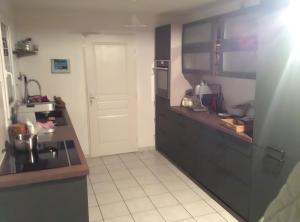 eine Küche mit schwarzen Schränken und weißem Fliesenboden in der Unterkunft Ty Gweltas - Chambre 300 plage in Saint-Gildas-de-Rhuys