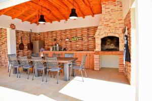 a kitchen with a table and chairs and a brick wall at Stone villa with pool in Galovac
