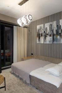 a bedroom with a large bed and a chandelier at Аренда квартиры #19 NRG U-Tower Rent an apartment in Tashkent