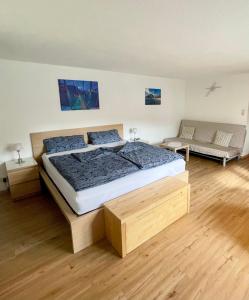 Un dormitorio con una cama grande y un sofá. en Modern Gemütlich, en Pflach