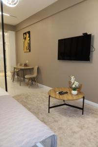 a room with a tv on a wall with a coffee table at Аренда квартиры #19 NRG U-Tower Rent an apartment in Tashkent