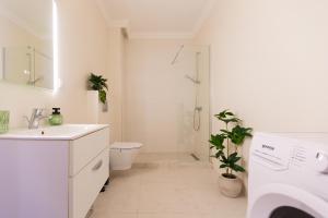 une salle de bain avec un lavabo, des toilettes et une douche dans l'établissement Quiet Premium Studio at Ivory Residence Pipera, à Bucarest