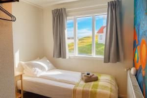 a small bedroom with a bed and a window at The Stykkishólmur Inn by Ourhotels in Stykkishólmur