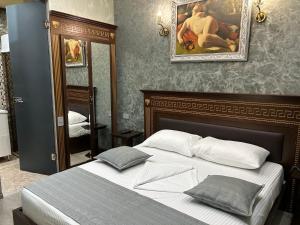a bedroom with a bed and a painting on the wall at Hotel Roma & Tours in Yerevan