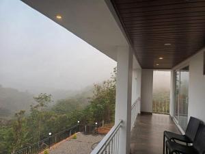 einen Balkon eines Hauses mit Bergblick in der Unterkunft Grand Sapphire Resorts & Travels Idukki in Idukki