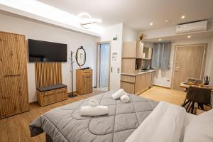 une chambre avec un grand lit avec des serviettes dessus dans l'établissement Gina's Apartments, à Spáta