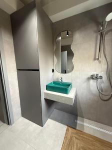 a bathroom with a green sink and a mirror at Апартамент САМИ 102 in Dobrich +20 photos