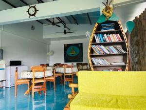 a dining room with a table and chairs and a book shelf at Bhūma in Havelock Island
