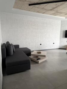 a living room with a couch and a coffee table at Апартамент САМИ 102 in Dobrich