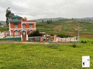 una casa en un campo con una valla en Bloom Hill Ooty, en Ooty