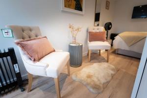 ボートン・オン・ザ・ウォーターにあるLetch Hill Driveのリビングルーム(椅子2脚、ベッド1台付)