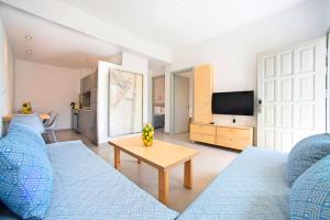 a living room with a blue couch and a tv at Elounda Garden Maxima Suite Beheiztes Schwimmbad in Elounda