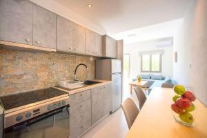 a kitchen with a table with a bowl of fruit on it at Elounda Garden Maxima Suite Beheiztes Schwimmbad in Elounda