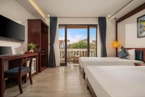 a hotel room with two beds and a balcony at Eco Hotel Hoi An in Hoi An +43 photos