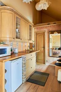 une cuisine avec des armoires en bois et un micro-ondes dans l'établissement Boutique Cottage, à Vilnius