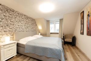 a bedroom with a bed and a brick wall at Heckenröschen in Grömitz