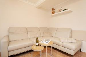 a living room with a white couch and a table at Heckenröschen in Grömitz