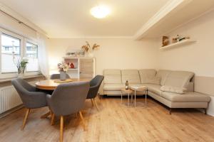 a living room with a couch and a table at Heckenröschen in Grömitz +32 photos